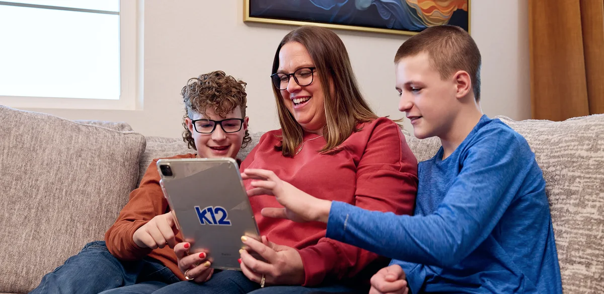 students smiling and looking the iPad